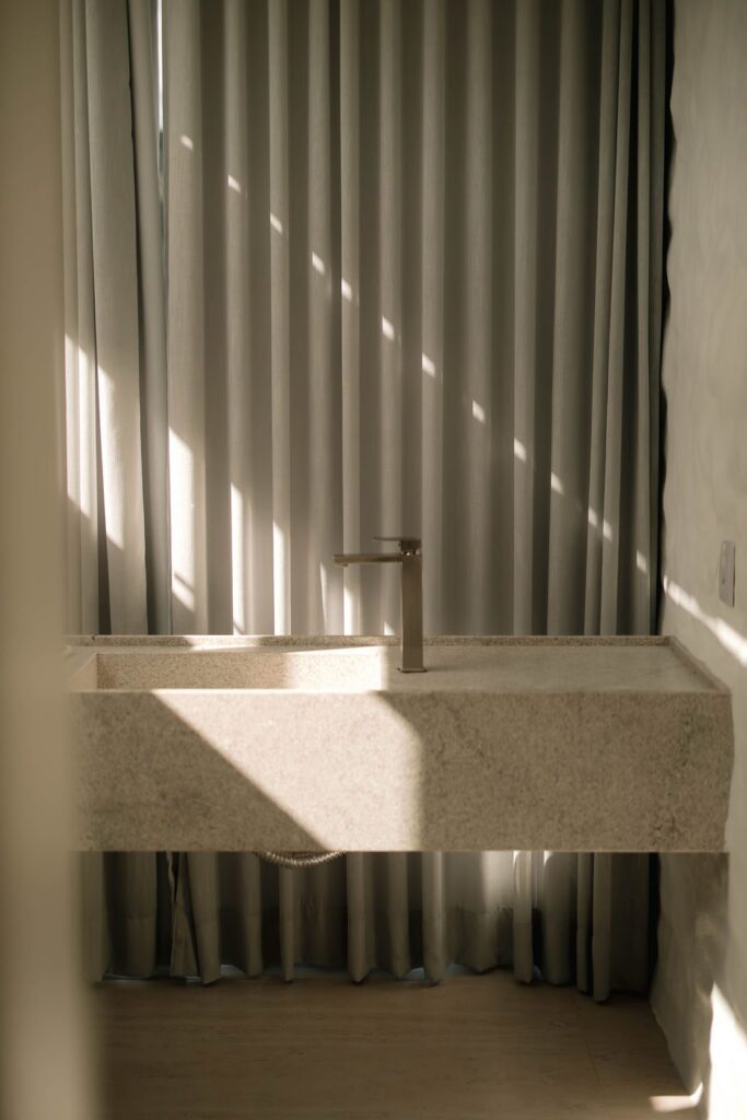 Bancada de pedra do banheiro do Loft Grécia com luz lateral
