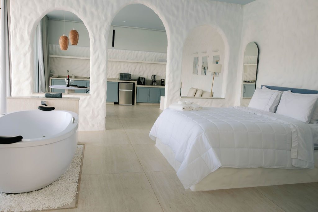 Vista ampla do Loft Grécia com hidromassagem e cama