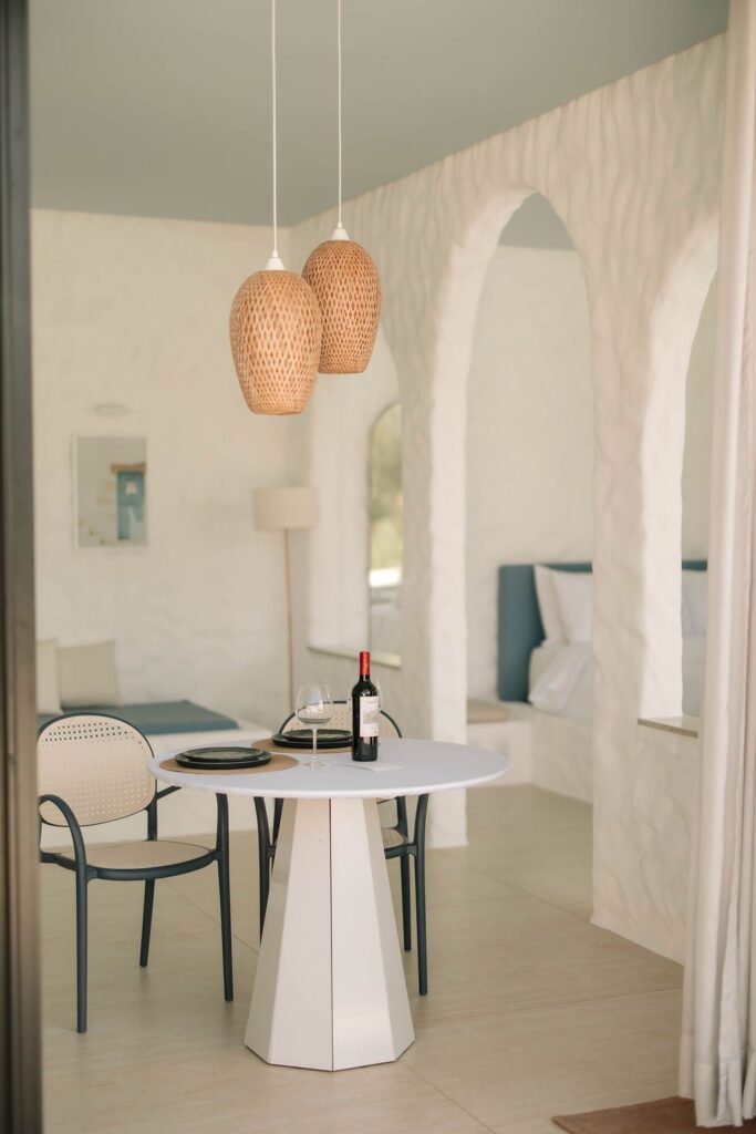 Mesa de refeição do Loft Grécia entre os arcos brancos