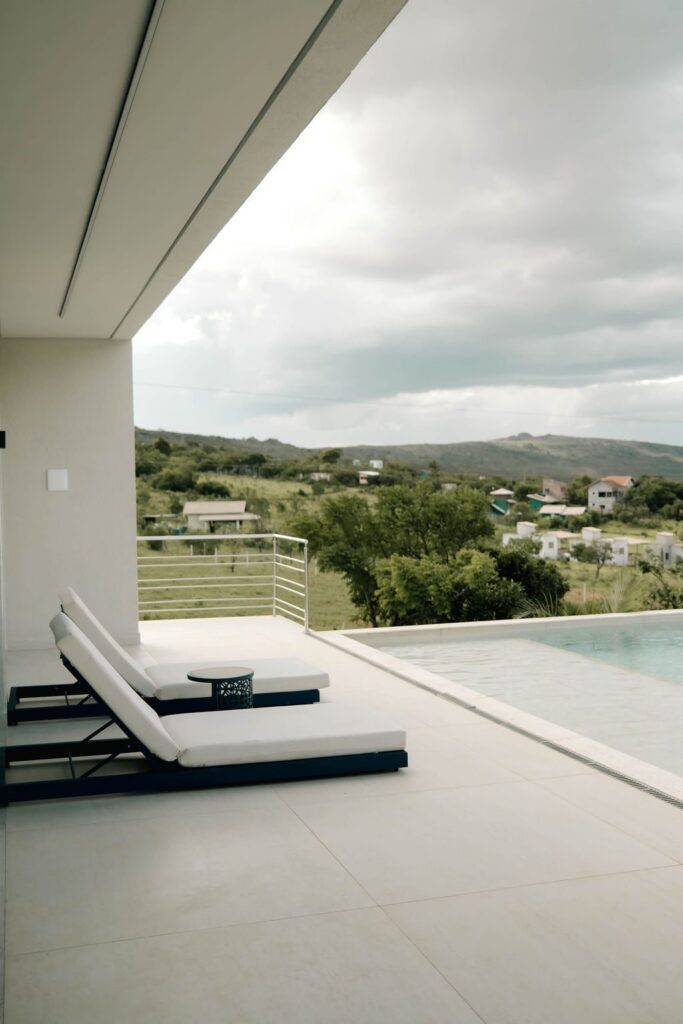 Terraço do Loft Grécia com espreguiçadeiras e piscina