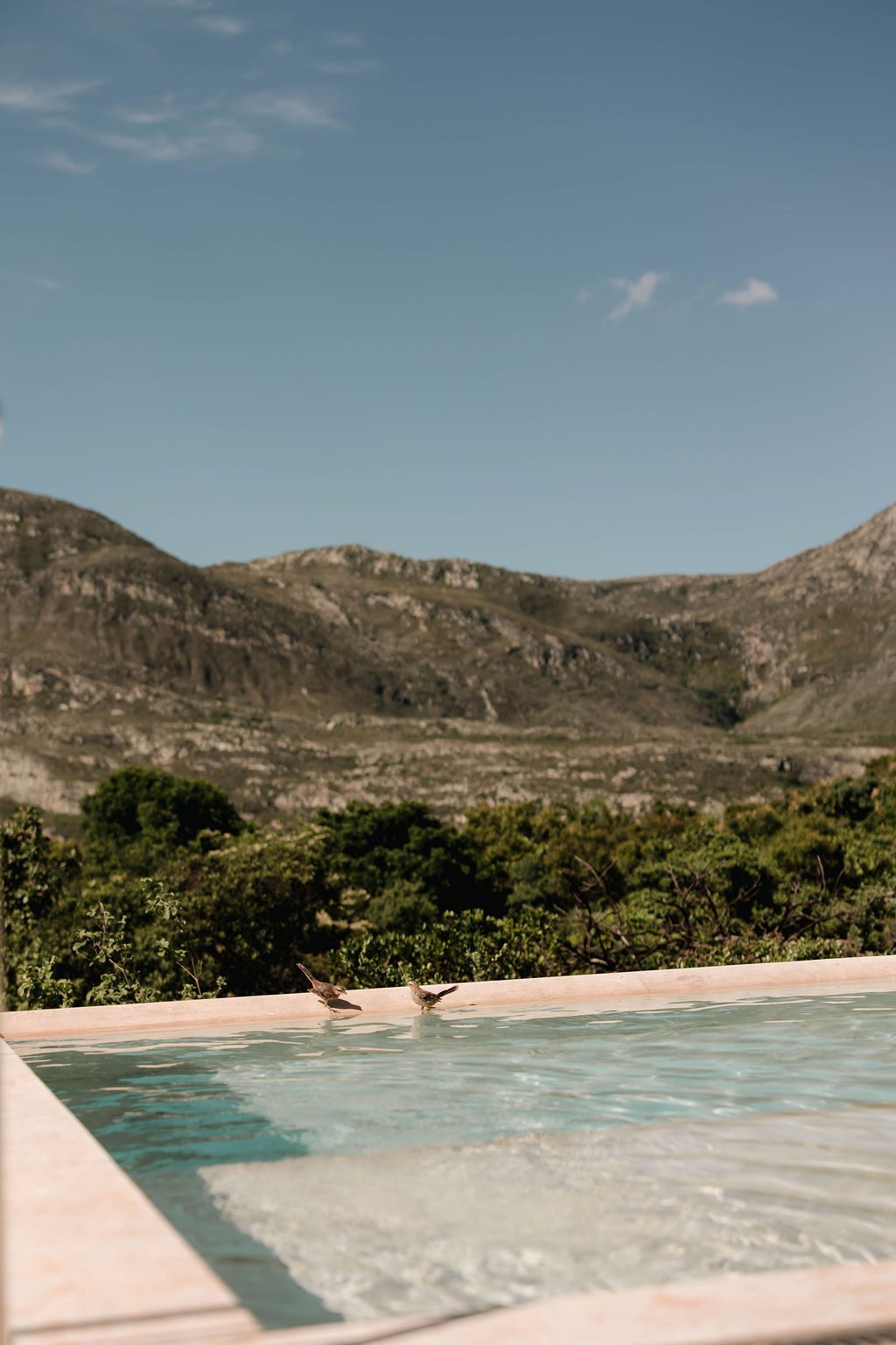 Borda da piscina alinhada com a montanha ao fundo