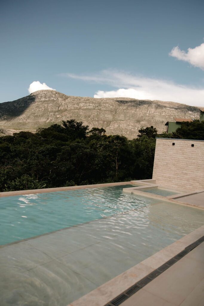 Piscina vista de cima com a serra e vegetação nativa