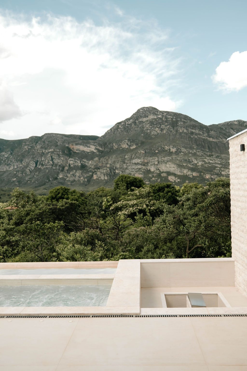 Piscina com a serra da Lapinha ao fundo em dia claro