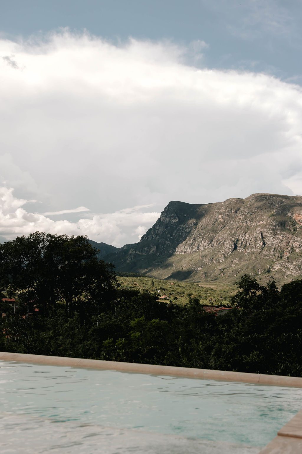 Piscina e serra sob céu nublado